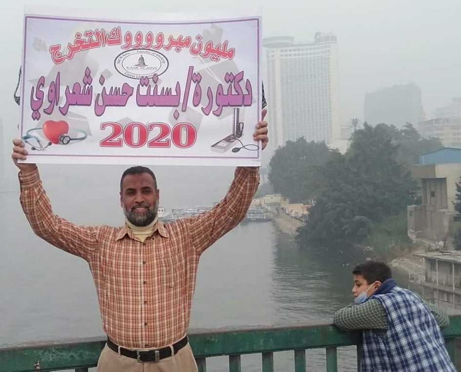 أب يحمل لافتة على كوبري عباس احتفالًا بتخرج ابنته